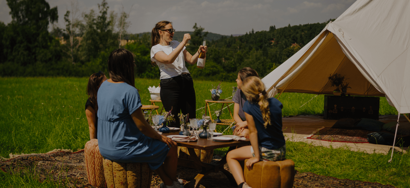 glamping lidi otvírají šampaňské před stanem Glamping lidi otvírají šampaňské před stanem